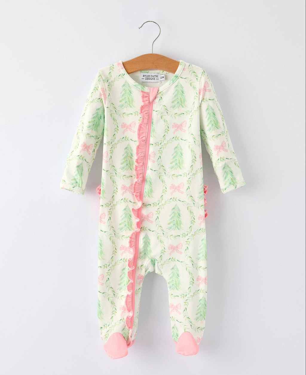 Baby onesie with pastel christmas pattern on a hanger against a white background