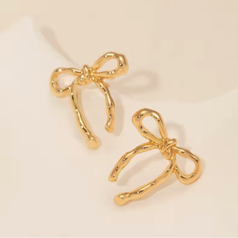 gold bow stud earrings on a white background