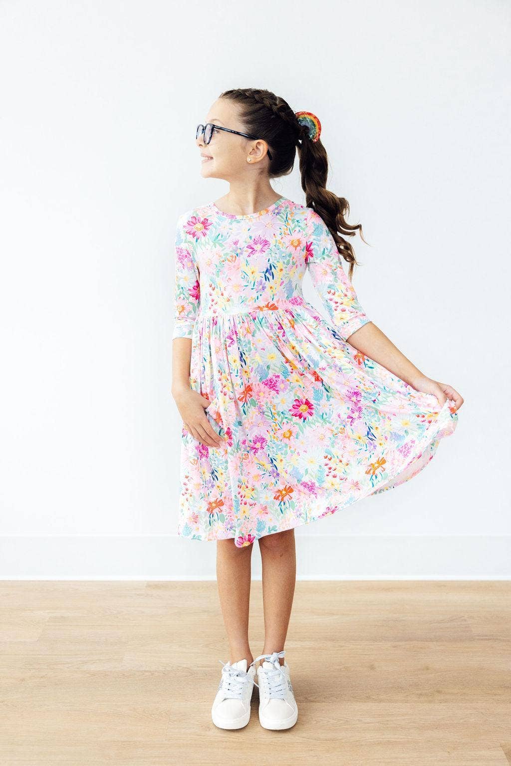Young girl wearing a floral dress against a white background