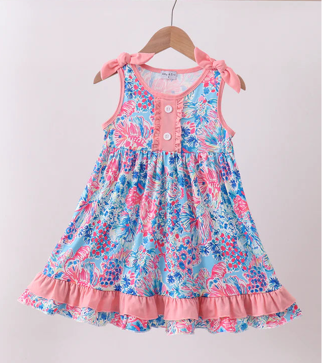 Floral dress on a hanger against a plain background