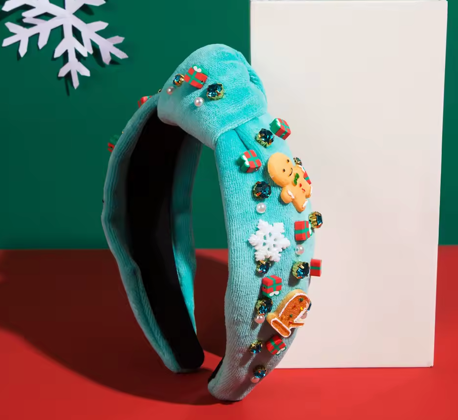 Decorative turquoise headband with Christmas-themed embellishments on a red and green background.
