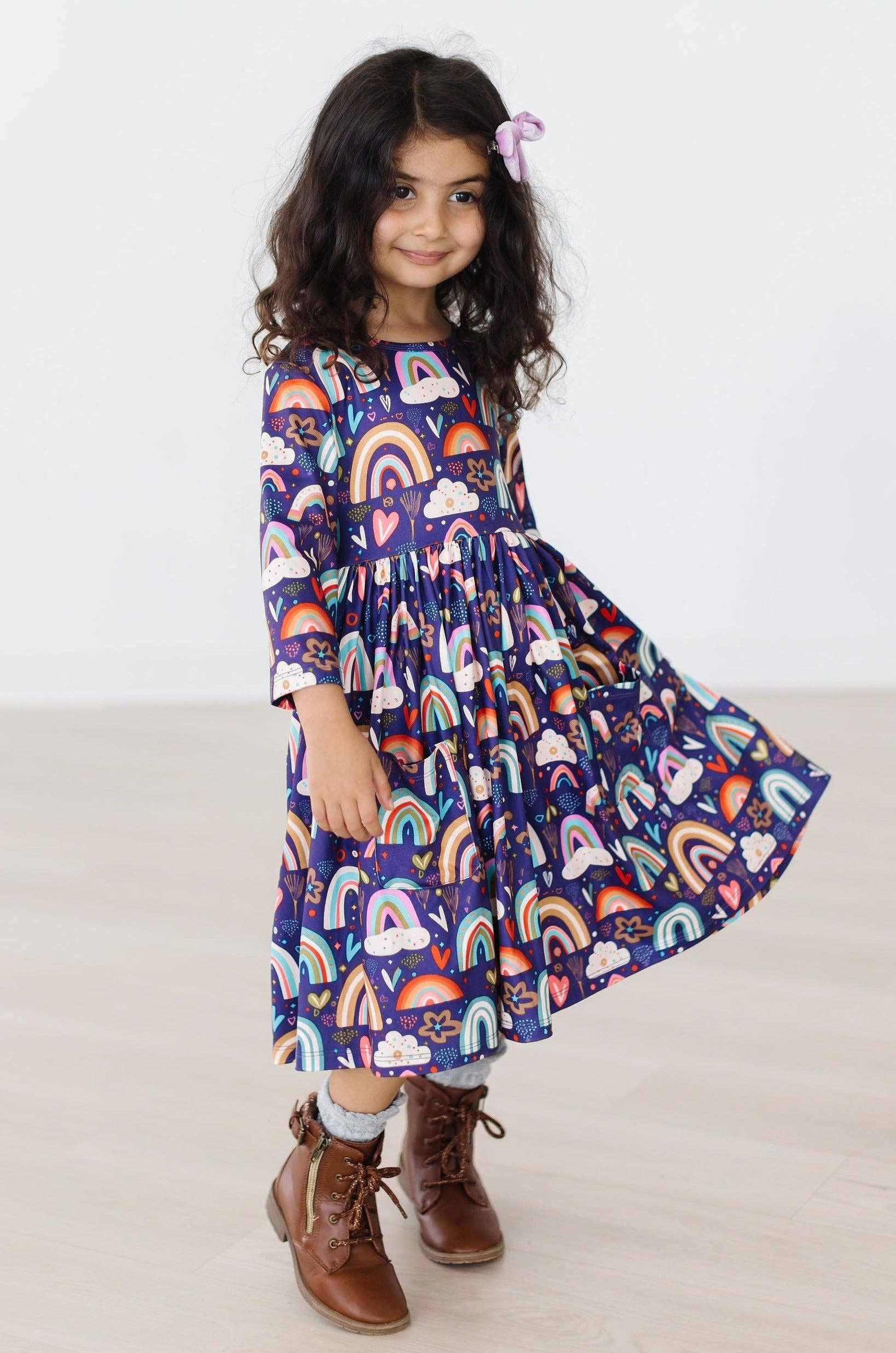 Young girl wearing a colorful rainbow dress on a white background